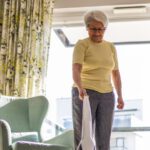 Senior woman getting exercise by vacuuming her living room