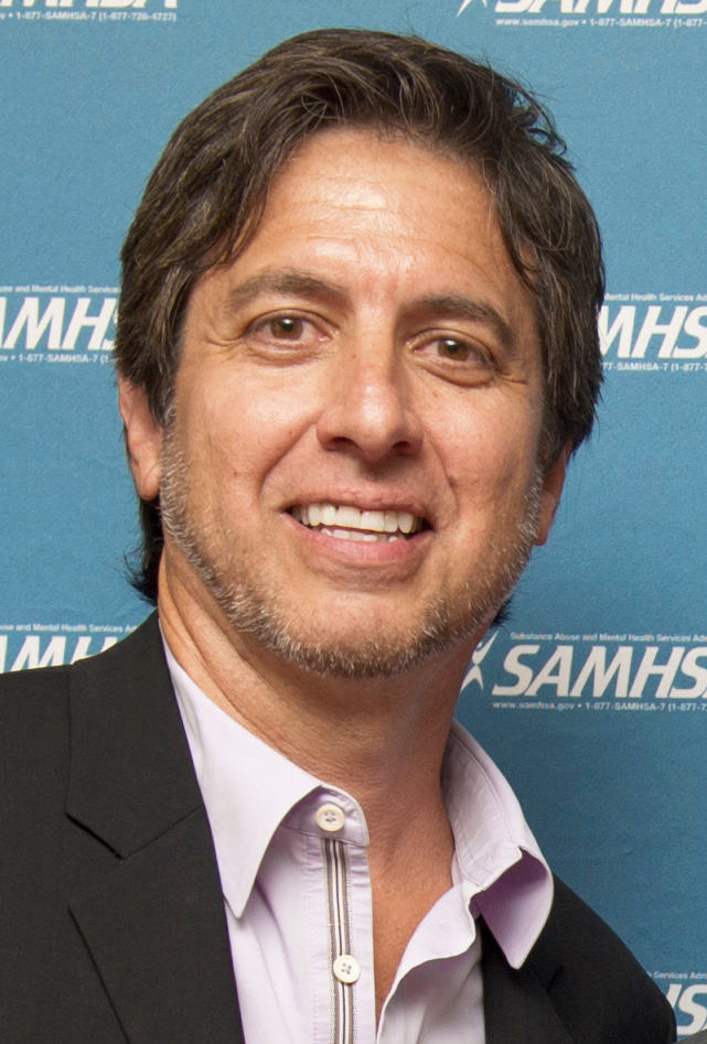 Actor Ray Romano smiling as he poses at an awards ceremony. 