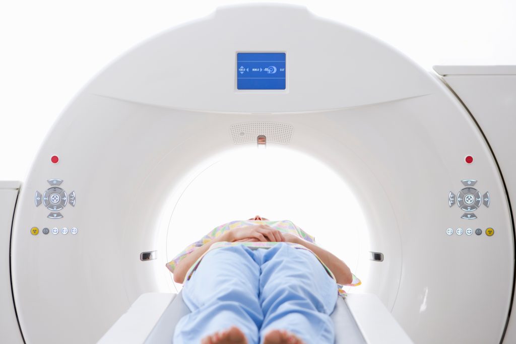Patient lying on a CT scanner table for preventive full body imaging.